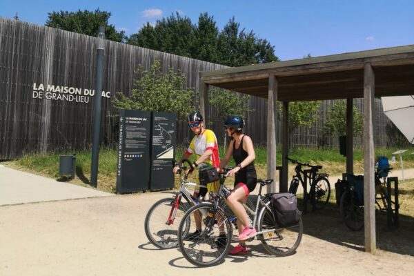 Des cyclistes devant La Maison du Lac de Grand-Lieu
